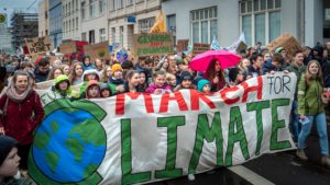 Viele Kinder demonstrieren mit einem großen Plakat für Fridays for Future