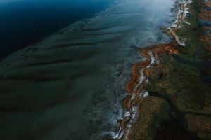 Eine Luftaufnahme von einer Küste, an der Öl ausgelaufen ist.