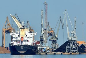 Auf dem Wasser liegt ein Industrieschiff neben mehreren Kränen